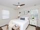 A staged bedroom features a ceiling fan, hardwood floors, and natural light from two windows at 4205 Woodlawn Dr, Raleigh, NC 27616