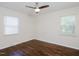 A bright bedroom showcases hardwood floors and natural light from two windows at 4205 Woodlawn Dr, Raleigh, NC 27616