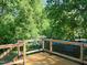 Wooden deck surrounded by lush trees, offering privacy and a scenic view at 4205 Woodlawn Dr, Raleigh, NC 27616