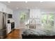 Bright kitchen features stainless appliances, white cabinetry, an eat-in area, and backyard access at 4205 Woodlawn Dr, Raleigh, NC 27616