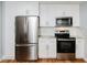 Modern kitchen features stainless steel appliances, white cabinets, and ample counter space for cooking at 4205 Woodlawn Dr, Raleigh, NC 27616