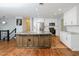 Bright kitchen boasts stainless appliances, white cabinets, and a unique countertop island with hardwood floors at 4205 Woodlawn Dr, Raleigh, NC 27616
