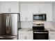 Updated kitchen features stainless steel appliances, white cabinets, and recessed lighting at 4205 Woodlawn Dr, Raleigh, NC 27616