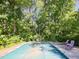 A backyard featuring a pool with a cover, chairs for lounging, and mature trees for privacy at 4205 Woodlawn Dr, Raleigh, NC 27616
