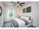 Bedroom features soft, neutral tones, a ceiling fan, large window with an outdoor view, and modern decor at 428 Providence Springs Ln, Fuquay Varina, NC 27526