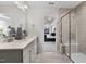 Bright bathroom featuring a double vanity, a glass-enclosed shower, and a glimpse into the bedroom at 429 Providence Springs Ln, Fuquay Varina, NC 27526