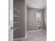 Functional laundry room with white wire shelving, a window and tiled floors at 429 Providence Springs Ln, Fuquay Varina, NC 27526