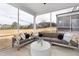 Screened-in patio area featuring an outdoor sofa and a round table, perfect for entertaining and relaxing at 429 Providence Springs Ln, Fuquay Varina, NC 27526