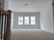 Bright, unfinished living room featuring three large windows for ample natural light at 4317 Emeline Way # 12, Fuquay Varina, NC 27526