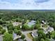 A high-angle view of a neighborhood, showing tennis courts, street and homes in a wooded landscape at 4902 Cedar Glen Dr, Durham, NC 27713