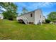 Exterior view of back of home with white siding, stairs, back porch and green lawn at 4902 Cedar Glen Dr, Durham, NC 27713