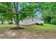 Backyard features a mature tree, green lawn and back porch perfect for outdoor entertaining at 4902 Cedar Glen Dr, Durham, NC 27713