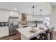 Bright kitchen boasts a large island with bar seating, stainless steel appliances, and stylish pendant lighting at 4902 Cedar Glen Dr, Durham, NC 27713