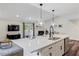 Open kitchen with pendant lights, white cabinets, and island overlooking living area at 4902 Cedar Glen Dr, Durham, NC 27713