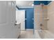The bathroom features tile shower and tub, blue painted walls, and white fixtures at 5619 Bennettwood Ct, Raleigh, NC 27612