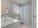 This is a bright bathroom featuring a shower with a modern curtain and a white single sink vanity at 5619 Bennettwood Ct, Raleigh, NC 27612