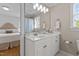 Bright bathroom features a white vanity, sink, and large mirror, with the bedroom in the background at 5619 Bennettwood Ct, Raleigh, NC 27612