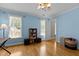 The bedroom features hard wood floors, soft-blue painted walls, and abundant natural light at 5619 Bennettwood Ct, Raleigh, NC 27612