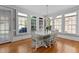 Sunlit dining room featuring hardwood floors, a chandelier, and large windows offering scenic views at 5619 Bennettwood Ct, Raleigh, NC 27612