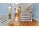 Lovely foyer with beautiful hardwood floors, stairs, bench, and views into the kitchen and powder room at 5619 Bennettwood Ct, Raleigh, NC 27612