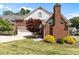 Rear exterior view of a brick home with a landscaped yard and attached garage at 5619 Bennettwood Ct, Raleigh, NC 27612