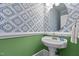 Stylish half bath featuring colorful patterned wallpaper, a pedestal sink, and modern lighting at 5619 Bennettwood Ct, Raleigh, NC 27612