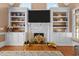 Close-up on a fireplace with a TV above and built-in bookshelves with décor at 5619 Bennettwood Ct, Raleigh, NC 27612