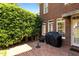 Brick patio with barbecue grill and adjacent green foliage, providing a private backyard setting at 5619 Bennettwood Ct, Raleigh, NC 27612