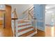 Elegant staircase with hardwood steps, white risers, and a charming blue accent wall at 5619 Bennettwood Ct, Raleigh, NC 27612