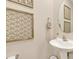 Stylish powder room featuring elegant fixtures, decorative macrame wall decor, and a pedestal sink at 636 Ginger Mint Cir, Knightdale, NC 27545