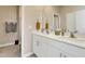 Bathroom featuring double sinks, white cabinets, and a door leading to the shower at 636 Ginger Mint Cir, Knightdale, NC 27545