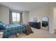 Bright bedroom with a blue bedspread, neutral walls, and ample natural light from a large window at 636 Ginger Mint Cir, Knightdale, NC 27545