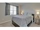 Well-lit bedroom with light grey walls and bedding and a dark accent wall at 636 Ginger Mint Cir, Knightdale, NC 27545