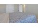Bedroom featuring light grey bedding with leaf pattern, two white doors, and neutral walls at 636 Ginger Mint Cir, Knightdale, NC 27545