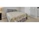 Spacious bedroom featuring plush carpet, gray paisley bedding, and a white door at 636 Ginger Mint Cir, Knightdale, NC 27545
