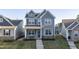 Charming two-story home with gray siding, manicured lawn, and inviting front porch and entry stairs at 636 Ginger Mint Cir, Knightdale, NC 27545