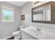 Well-lit bathroom with a white vanity, framed mirror, and a window at 640 Short Journey Rd, Smithfield, NC 27577