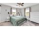 Cozy bedroom featuring a metal bed frame, soft green bedding, and natural light from two windows at 640 Short Journey Rd, Smithfield, NC 27577