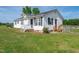 Beautiful home with white siding, black shutters, green grass, and a cozy front porch at 640 Short Journey Rd, Smithfield, NC 27577