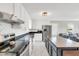 Well-lit kitchen with island, white cabinetry, and modern appliances, adjacent to a cozy living space at 640 Short Journey Rd, Smithfield, NC 27577