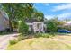Inviting single-story home with landscaped front yard, driveway, and lush trees at 708 Mills St, Raleigh, NC 27608
