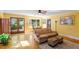 Bright, light-filled living room with neutral sofa, patterned ottomans, ceiling fan, and hardwood floors at 708 Mills St, Raleigh, NC 27608