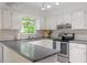 Well-lit kitchen with white cabinets, stainless steel appliances, and gray countertops at 7213 St Ledger Dr, Raleigh, NC 27613