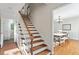 Bright foyer with hardwood staircase leading to dining room with natural light at 7213 St Ledger Dr, Raleigh, NC 27613