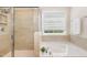 Luxurious bathroom featuring a tiled shower, soaking tub, and a bright window for natural light at 7508 Channery Way, Raleigh, NC 27616