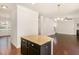 Modern kitchen island features granite countertops and dark cabinets overlooking the spacious living area at 7508 Channery Way, Raleigh, NC 27616
