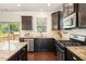 Stylish kitchen with dark cabinets, stainless steel appliances, granite countertops, and backyard access at 7508 Channery Way, Raleigh, NC 27616