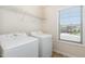 Functional laundry area equipped with a washing machine, dryer and storage shelf at 7508 Channery Way, Raleigh, NC 27616