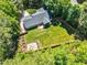Aerial view of the home with an expansive backyard, lush greenery, and a cozy fire pit area at 76 Bergeson Ct, Fuquay Varina, NC 27526