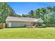 Grassy backyard area featuring a small deck, a covered porch, and a sturdy wooden fence for added privacy at 76 Bergeson Ct, Fuquay Varina, NC 27526